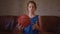 Serious white man teenager holding basketball ball and sitting in living room, young teen athlete, sport portrait at