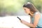 Serious woman checking phone online content in a park