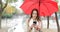 Serious woman checking phone under the rain