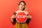 Serious woman holding and showing red stop sign, concerned about women rights, demanding equality