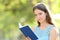 Serious woman looks at camera holding a book