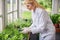 Serious woman scientist bending over thyme seedlings