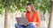 Serious woman uses a laptop on a bench