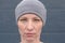 Serious woman wearing gray beanie hat