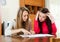 Serious women looking financial documents at table