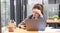 serious young Asian businesswoman at her office desk dealing with a smartphone problem or receiving a complaint email from her