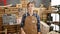 Serious young blonde woman carpenter standing with arms crossed in her carpentry workshop