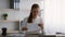 Serious young businesswoman opening envelope and reading letter at workplace in office