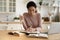 Serious young Latina woman studying seated at dining table