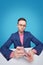 Serious young man in formalwear and eyeglasses mixing playing cards over desk