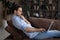 Serious young man sit on sofa engaged in computer work