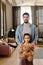 Serious young man standing by his little pretty daughter with soft brown teddy