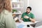 Serious young middle eastern guy ceo at table with laptop talking to manager with smartphone