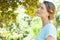 Serious young woman looking at leaves in park