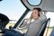 Serious young woman pilot in headset sitting in plane