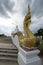 The serpent statue and the big white Buddha are beautiful under cloudy sky