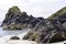 Serpentine rock cliffs at the tide edge at Kyance Cove in Cornwall