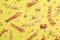 Serpentine streamers and heart shaped confetti on yellow background, flat lay