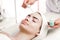 Serum facial treatment of young woman in spa salon