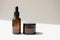 Serum oil essence in brown glass bottle and cream in jar on light beige background with diagonal shadow. Mockup beauty cosmetic