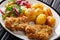 Serve fried steaks in sesame breading with new potatoes and fresh salad close-up on the table. horizontal