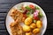 Serve fried steaks in sesame breading with new potatoes and fresh salad close-up on the table. horizontal top view