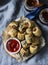 Served appetizers table - minced puff pastry rolls and beer on grey background, top view. Flat lay.