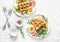 Served breakfast with potatoes savory waffles, boiled egg, ham and arugula on light background, top view. Appetizers, snack, brunc