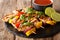 Served grilled chicken kebab skewers with vegetables with sauce, herbs and lime closeup on a slate plate. horizontal