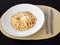 Served spaghetti carbonara in white plate on table