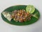 Served with steamed fish yellowtail scad with matah chili sauce on a wooden oval plate