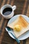 Served table for breakfast with toast, coffee and butter on tablemat