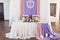 Served wedding banquet table in the restaurant decorated white, pink and purple material, white and pink flowers and greenery.