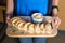 Server holding wooden tray with freshly baked bread and homemade butter. Women\'s hands with wooden server of appetizers.