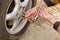 Service process. A man holds a tire in the garage. Replacing winter and summer tires. Seasonal tire replacement concept