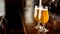 Service at pub. Glasses with beer in light on wooden bar counter