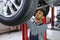 service, repair and profession concept - indian mechanic at car service