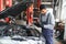 service, repair and profession concept - indian mechanic at car service