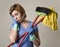 Service woman in washing rubber gloves carrying cleaning broom m