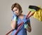 Service woman in washing rubber gloves carrying cleaning broom m