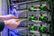 Service work in the datacenter server room. The hand of a technician with a communication Internet wire is a close-up.