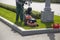 A service Worker mows the lawn with a lawn mower