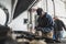 serviceman checking a car and writing results on a paper, auto repair shop