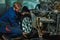 Serviceman checking suspension in a car at garage. Mechanic repaired wheeled vehicles. Mechanic Holding Car Tire At Garage. Mechan