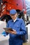 Serviceman with digital tablet on the background of the truck in the car service