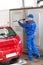Serviceman With High Pressure Water Jet Washing Car