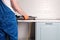 Serviceman installs  new gas hob in  kitchen countertop