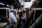 A serviceman in an intercity bus offers passengers refreshing drinks and light snacks. Night flight between major cities.