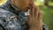 Serviceman praying, sitting outdoors, national hero, patriotic american soldier