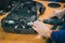 Serviceman stripping and removing electric motors on robotic lawnmower, motorized lawnmower being serviced on a table after a year